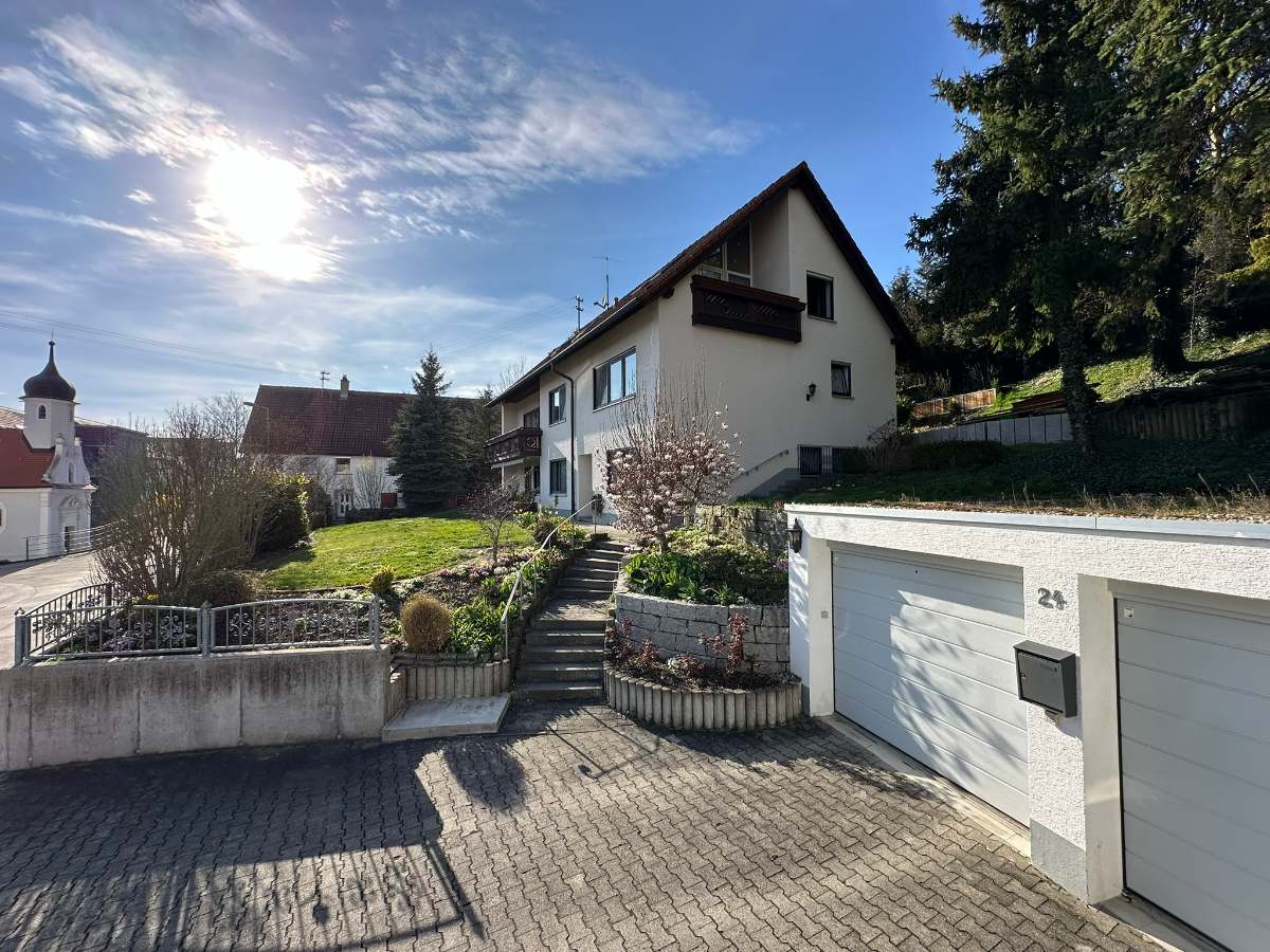 Außenansicht des Mehrgenerationenhauses in Nasgenstadt mit Garten, Garage und Blick auf den Ort