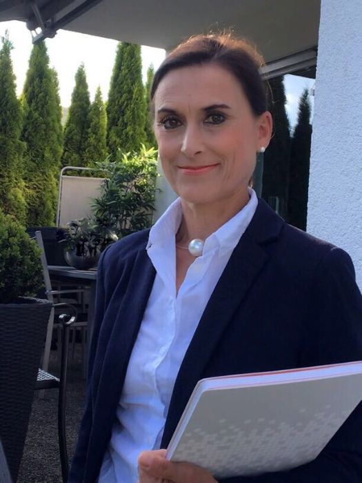 Verena Maurer, Immobilienmaklerin in Ulm, mit einer Mappe auf ihrer Terrasse